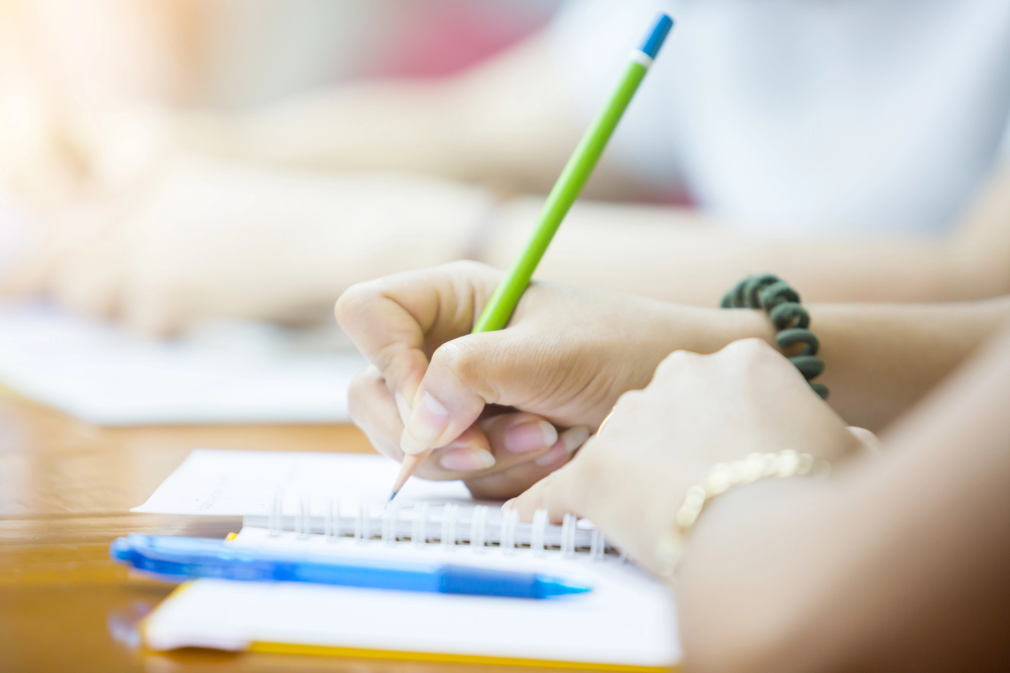 manos de estudiante joven escribiendo sobre su libreta